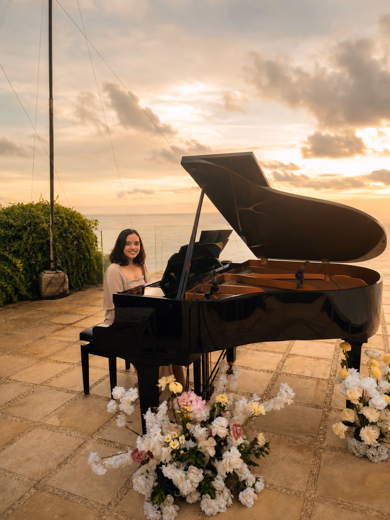 Grand piano set up for a cliffside wedding ceremony in Bali at sunset