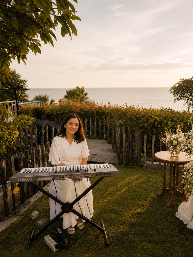 Wedding pianist performing in a garden pathway at sunset in Bali